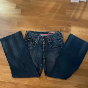 Supersnygga bootcut jeans - Supersnygga bootcut midrise  jeans med dekorerade fickor och ett spänne där bak Sitter supebra, lite kortare modell, runt storlek 26, priset kan diskuteras  Priset kan diskuteras