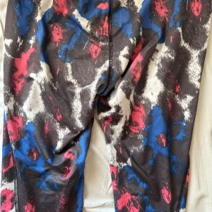 Färgglada Träningsbyxor - Säljer dessa supersköna träningsbyxorna som jag inte har använt på flera år då de tyvärr har blivit alldeles för små för mig. Det hänger en lös tråd vid ena benet + några små lösa trådar nere vid foten, men i övrigt är dessa byxorna i gott skick.