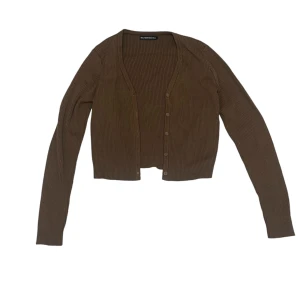 Brun ribbad kofta - Säljer en snygg brun ribbad kofta från Brandy Melville med knappar framtill. Den är croppad och har långa ärmar, perfekt för höst och vår. 🤎Den är one size men skulle säga att den passar XS/S.