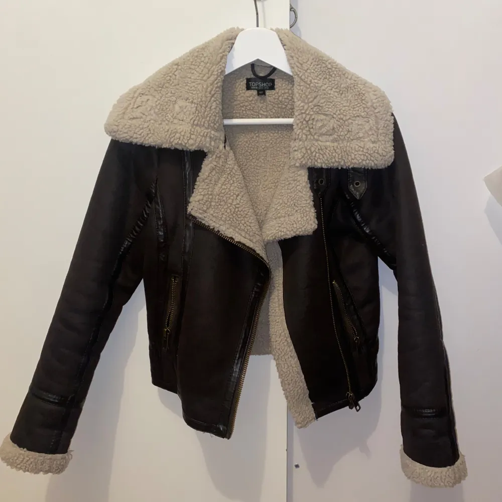 Skitsnygg jacka med teddymaterial inuti, coola spännen vid halsen. För liten för mig med S, främst i ärmarna. Superfint skick, endast använd ett par gånger. Mörkbrun med beige material inne. Takit.