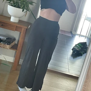 Mjukisbyxor ribbade - Ribbade mörkgrå mjukisbyxor i lätt tyg som faller fint över kroppen. Resor i midjan. Från Anna Field i modell tall. Passar M. Jag är 170cm för referens.