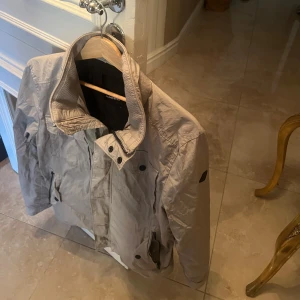 J.Lindberg jacka! - J.Lindberg bailey jacka i färgen Beige! Väldigt sällsynt och nypris ligger runt 4 tusen. I väldigt bra skick endast att den är lite skrynklig men går att stryka enkelt! 