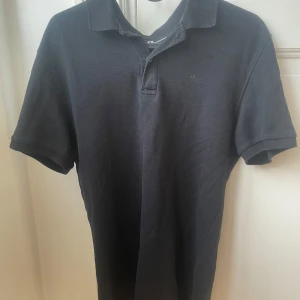 Svart J.lindeberg piké. - Svart J.lindeberg piké som använt 10-20 gånger. Inget tyder på använt dock. Ny för cirka 900kr och säljer pga tröttnat. Pris kan diskuteras!👌