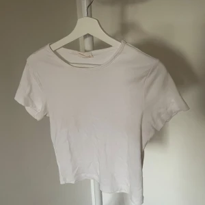 Vit och svart kortärmad topp - Två stilrena toppar i vitt och svart. Perfekta basplagg med korta ärmar och rund halsringning. Köpta på ginatricot. Knappt använda