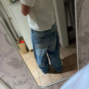 Hella baggy jeans - Säljer ett par bershka baggy jeans med en avslappnad passform. De har en klassisk femficksdesign och är perfekta för en casual look. Midjan är midwaist och de har en rak benstil. Lite heelbite
