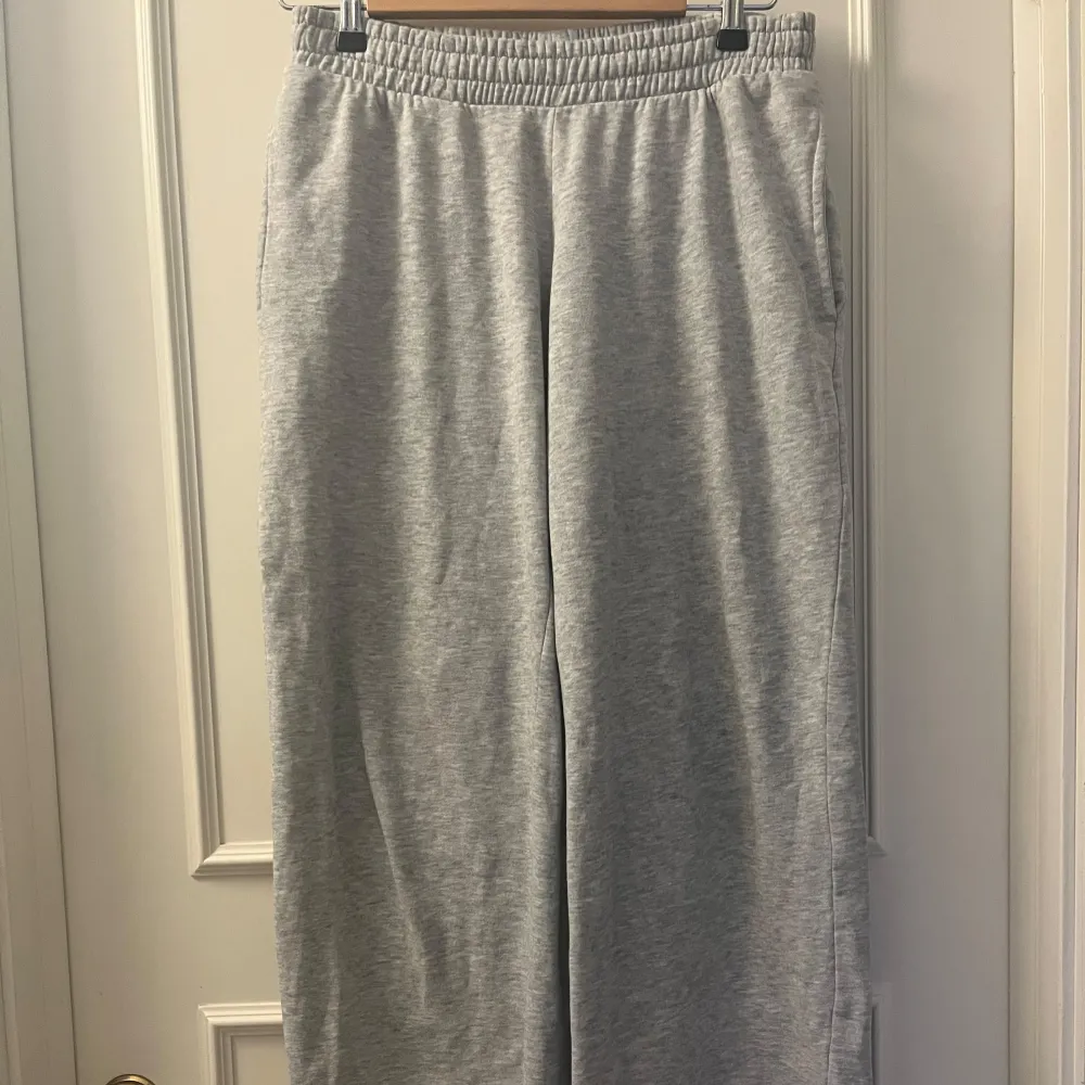 Säljer ett par bekväma grå mjukisbyxor med elastisk midja. Perfekta för en avslappnad stil. De är från bikbok och säljer de för att de är lite korta på mig som är 174cm. Skulle kanske passa någon som är 170cm och neråt. De är inte använda mycket.. Farkut & Housut.