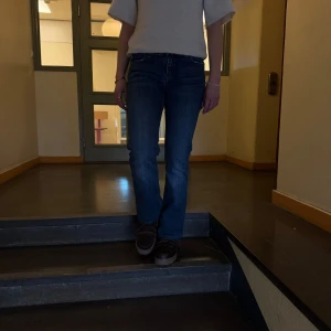 Blå jeans från Levi's - DROP 01!!!!     Snygga blå jeans från Levi's med klassisk femficksdesign och knappgylf. De har en normal passform och är perfekta för en avslappnad stil. Jeansens mörkblå färg gör dem lätta att matcha med olika toppar.