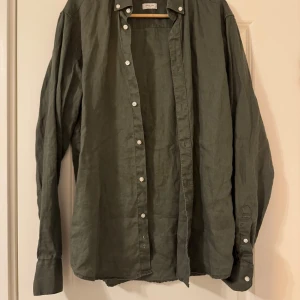 Grön linneskjorta från Bruun & Stengade - Snygg grön skjorta i linne från Bruun & Stengade. Skjortan har en casual slim passform och långa ärmar med knappar framtill. Perfekt för en stilren och avslappnad look. Nypris 1000kr! 