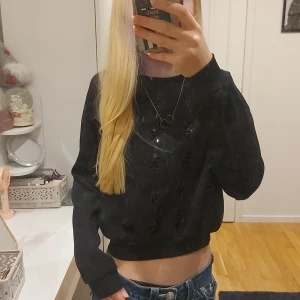Svart croppad tjocktröja - Säljer en svart croppad tröja med långa ärmar. Små paljetter i fronten. Storlek: XS/S🩷🩷 Skriv självklart vid frågor!🩷 Använts 1 gång!🩷