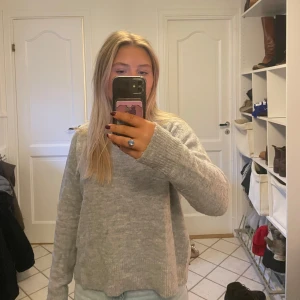 Grå stickad tröja - Säljer en mysig grå stickad tröja med rund hals och långa ärmar. Passar perfekt nu till vintern! Är liten i storleken!