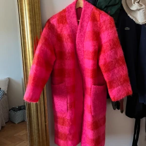 Unik rosa och röd kappa i ull - Helt underbar kappa som gör ont att sälja, men tyvärr använder jag inte den så ofta som den förtjänar. Den är i fint skick. Saknar storlek men skulle säga att den gör sig bäst på XS/S. Material ull och mohair.