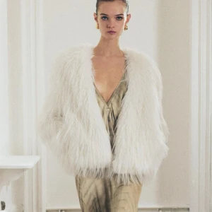 Vit pälsjacka Zara ny - Elegant vit pälsjacka med en lyxig och fluffig look. Perfekt för att ge en glamorös touch till din outfit. Jackan har en öppen design utan knappar eller dragkedja. Helt ny från Zara nypris 999