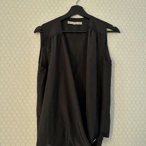 Svart omlott topp från & Other Stories - Snygg svart topp från & Other Stories i en stilren design. 