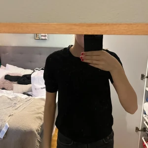 Svart t-shirt från Lindex - Säljer en ribbstickad svart t-shirt från Lindex i storlek XS. T-shirten har en normal passform och är kortärmad, perfekt för en stilren look. Tillverkad i ett mjukt material som känns skönt mot huden.