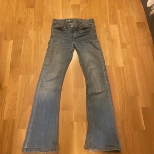 Blå jeans från LAB Industries - Säljer ett par blå jeans från LAB Industries i storlek 140. De har en bootcut-stil och är tillverkade av hållbart denim. Perfekta för en avslappnad look.