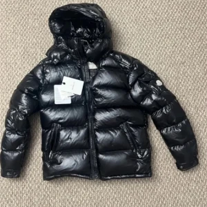 Svart jacka från Moncler - Säljer en snygg svart jacka från Moncler. Jackan har en glansig finish och är utrustad med en dragkedja framtill. Perfekt för kalla dagar med sin varma och puffiga design. Den har en luva och långa ärmar för extra skydd mot väder och vind.