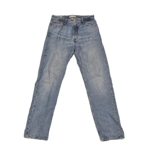 Blå jeans från Jack & Jones - Säljer ett par klassiska blå jeans från Jack & Jones. De har en straight passform och är tillverkade i slitstarkt denim. Perfekta för en avslappnad stil.