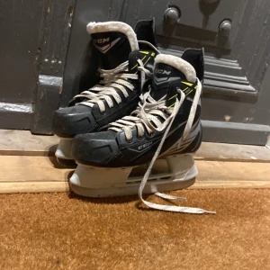 Svarta skridskor från CCM - Säljer ett par svarta skridskor från CCM med vita snören och detaljer i silver  och gult. Skridskorna är i bra skick storlek  36.