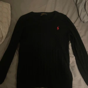 Svart kabelstickad tröja från Ralph Lauren - Säljer en svart stickad ralph lauren tröja då den inte passar mig längre. Storlek S och är lite för liten för mig som är 175cm. Ny pris på tröjan är ungefär 1200-2000kr. 