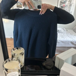 Mörkblå stickad tröja från H&M - Säljer en stilren mörkblå stickad tröja från H&M Tröjan har en rund halsringning och långa ärmar, perfekt för kyligare dagar. Passar bra till både jeans och kjol.