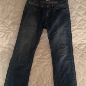 Blå jeans från American Classic Jeans  - Säljer ett par klassiska blå jeans från American Classic Jeans, modell Grant. De har en regular fit och är tillverkade i högkvalitativt, starkt denim. Perfekta för en avslappnad stil. W34 L34