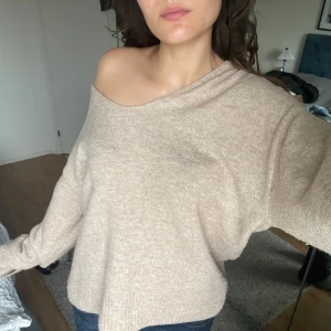 Beige stickad tröja från H&M - Säljer en mysig beige stickad tröja från H&M. Tröjan har en v-ringad design och långa ärmar