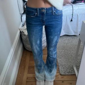 blå bootcut jeans i tie dye - säljer dessa blå/ljusblå blekta byxorna i tie dye mönster. materialet är lite stretchigt men skulle säga att de passar XS-S. jag är ca 170 och midjemåttet är 35 tvärs över, innerbenslängden är ca 83.