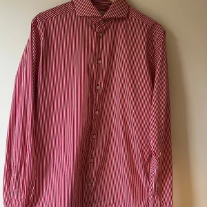Röd- och vitrandig skjorta från Eton - Säljer en stilren röd- och vitrandig skjorta från Eton i storlek 42. Skjortan har en slim passform och är tillverkad i ett mjukt bomullsmaterial. Perfekt för både vardag och fest! Den har långa ärmar och knappar framtill. Ett måste i garderoben för den som gillar klassisk stil.
