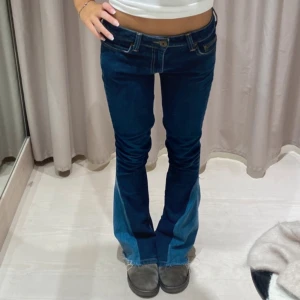 Mörkblå bootcut jeans - Säljer ett par snygga mörkblå bootcut jeans i bra skick. De är lågmidjade och har en cool dragkedjedetalj vid bensluten. Perfekta för både vardag och fest! 🕺