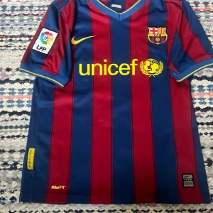 Äkta Thierry Henry Barcelona tröja 2009/10 - Säljer min äkta Thierry Henry tröja eftersom den blivit för liten. Den är i str m i barn (152). (Nike) Framsidan på tröjan är i mycket fint skick! Nummerna på baksidan håller på att lossna(sista bilden) Hör av dig om du undrar något. Rekommenderar 