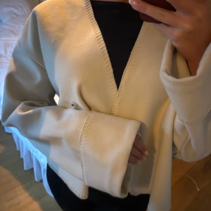 Beige jacka  - Säljer en superfin beige jacka med omlott-design. Den har en loose passform och långa ärmar, perfekt för höst och vår. Jackan är i mycket bra skick och har en stilren look som passar till det mesta. Perfekt för dig som vill ha något stilrent och bekvämt!