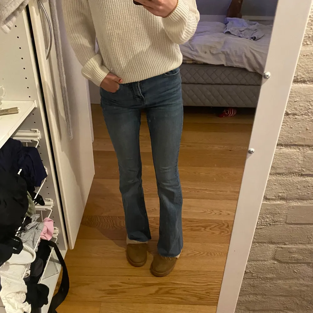 Säljer ett par snygga blå bootcut jeans i bra skick. De är lågmidjade och har en klassisk femficksdesign med dragkedja och knapp. Perfekta för både vardag och fest! Passar bra till en stickad tröja eller en snygg topp.. Jeans & Byxor.