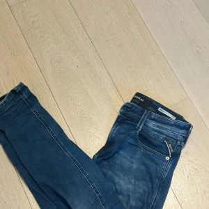 Replay jeans blå - Jag säljer ett par blå replay jeans som är slim fit anbass. Väldigt fina och bra passform. Storlek 30/32. Andvända ganska mycket men ändå fint skick finns en deffekt som är ett hål mitt på byxorna vid skrevet. Går förmodligen att laga för  💯kr vid en skräddare