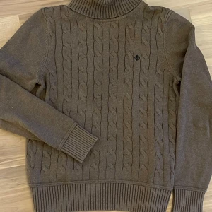 Brun Cable knit tröja från Morris - Säljer en snygg brun stickad tröja från Morris. Den har ett klassiskt Cable knit och en hög ribbad krage som håller dig varm. Perfekt för höst och vinter! Tröjan är i mycket bra skick och passar både till vardags och lite finare tillfällen. Strl M/s