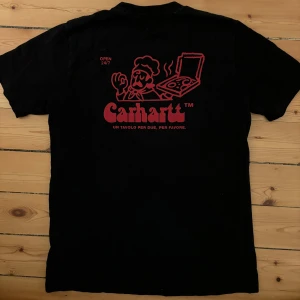 Unik t-shirt från Carhartt med pizzatryck - Säljer en svart t-shirt från Carhartt med ett coolt rött pizzatryck på både fram- och baksidan. T-shirten är i bra skick och har en normal passform!🍕nypris 500