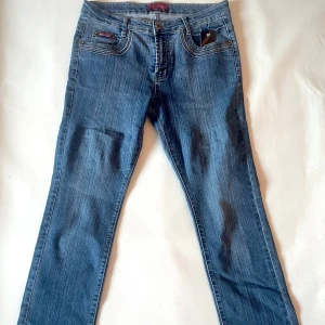 Blå jeans från H&L - Säljer ett par klassiska blå jeans från H&L i bra skick. De har en snygg straight passform och är perfekta för vardagsbruk. Jeansen har en knapp och dragkedja framtill samt fem fickor. Perfekta för både höst och vår!