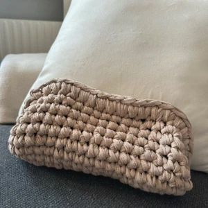 Beige virkad handväska - Säljer en superfin beige stickad handväska. Den är handgjord med ett grovt virkad mönster som ger en mysig och unik känsla. Perfekt för att bära med sig småsaker till vardags eller som en söt accessoar till en avslappnad outfit. 👜✨