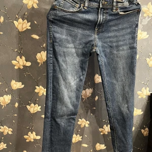 Blå jeans från Jack & Jones - Säljer ett par klassiska blå jeans från Jack& Jones i  bra skick. De har en snygg tvätt och är perfekta för vardagsbruk. Jeansen har en knappgylf och fem fickor. Passar perfekt till både sneakers och kängor. Perfekt för höst och vår!