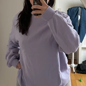 Ljuslila sweatshirt - Säljer en supermysig ljuslila sweatshirt i mycket bra skick. Den har en avslappnad passform och långa ärmar, perfekt för både vår och höst. Tröjan är gjord i mjukt material och är idealisk för en chill dag hemma eller en promenad i parken. Passar perfekt till jeans eller leggings!