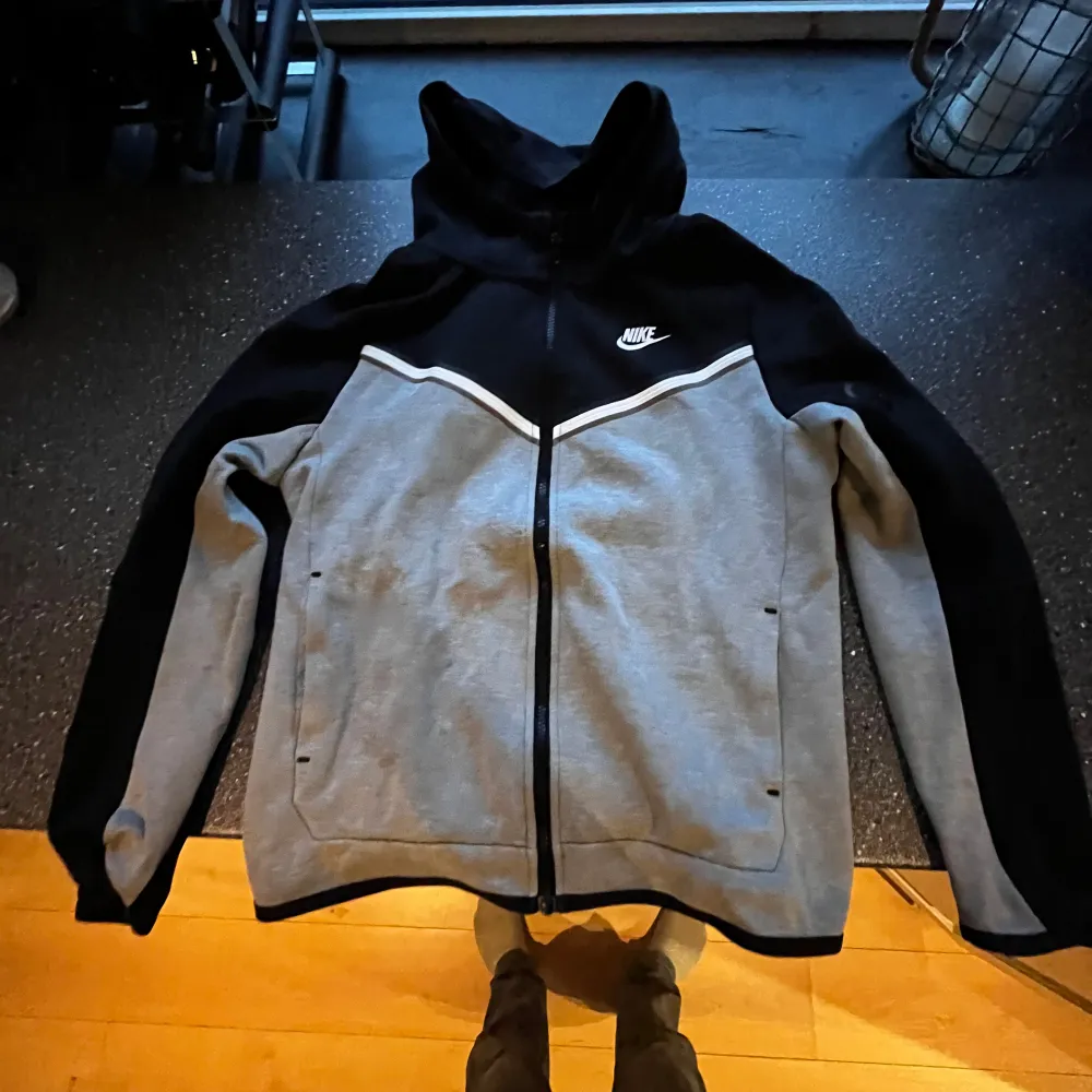 Säljer en snygg och bekväm grå och svart hoodie från Nike i storlek XL/170cm, Den har en dragkedja framtill och är perfekt för både höst och vår. Hoodien är i bra skick och har långa ärmar. Perfekt för en sportig look eller bara för att chilla hemma.. Jackor.