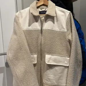 Säljer en supermysig beige teddyjacka från A.P.C. med dragkedja framtill. Jackan har stora fickor och en klassisk krage. Perfekt för höst och vår när du vill hålla dig varm och stilren. Passar både till vardags och lite finare tillfällen. 🧥✨