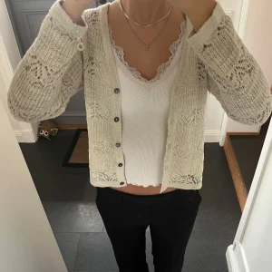 Beige/glittrig stickad kofta  - Mönstrad stickad kofta från Carin i storlek S. Fint skick. Använd gärna köp nu!