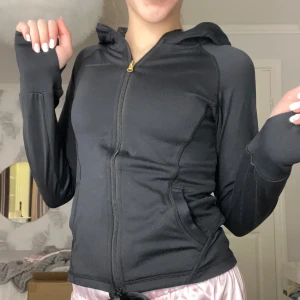 Svart huvtröja från swedemount - Säljer en svart huvtröja från swedemount med dragkedja och långa ärmar. Tröjan har en slim passform och är perfekt för träning eller vardagsbruk. Den är tillverkad i ett mjukt och stretchigt material för maximal komfort. Kostade 300 kr när jag köpte den. Är använd fåtal gånger. Den är så himla skön och perfekt för allt! 😍