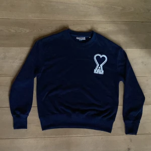 Mörkblå tröja från Ami - Säljer en stilren mörkblå tröja från Ami med ett unikt hjärtmönster på bröstet. Pris kan diskuteras.