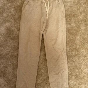 Beige linnebyxor från Zara - Snygga beige byxor med dragsko i midjan. Byxorna har en rak passform och är tillverkade i en mjuk och skön kvalitet. Perfekta för både vardag och fest.  Kombinera med alla typer av kläder och den passar till nästan allt Märke: Zara Storlek :M Skick: 8/10  ord. Pris 399