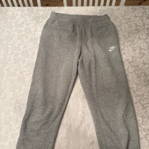 Grå mjukisbyxor från Nike - Säljer ett par grå mjukisbyxor från Nike i storlek M. De är gjorda i mjukt material. Köparen betalar för frakten. 
