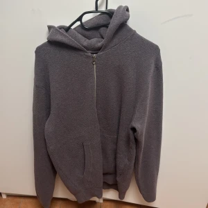 Grå hoodie med dragkedja - Säljer en mysig grå hoodie med dragkedja framtill. Perfekt för kyliga dagar med sin mjuka och bekväma design. Den har en praktisk huva och fickor för extra värme och stil. Storlek Small men funkar även för Medium säljs för 600kr
