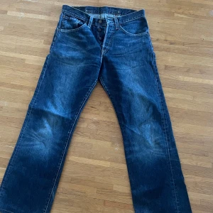Levis 501 jeans i mörkblå denim - Klassiska Levis 501 jeans i mörkblå denim. Dessa jeans har en rak passform och är tillverkade i slitstarkt denimtyg. De har en knappgylf och femficksdesign med den ikoniska Levis-lappen på baksidan. Perfekta för en avslappnad stil. Kan alltid diskutera pris💞