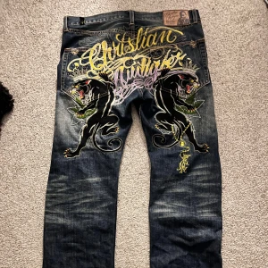 Jeans Ed Hardy by Christian Audigier med broderade detaljer - Väldigt grisch tillbakalutad baggy jeans med bra kvalitet och knappast använda. Väldigt sällsynta och exlusiva. Pris kan prutas och diskuteras och ändras om man vill känna för sånt. Storlek: baggy saggy och långa så de ger najs folding