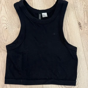 Svart topp - Svart ribbad topp, jättefin till sommaren. Säljer då jag växt ur den. Fläcken den har på bilden har tvättats bort :)